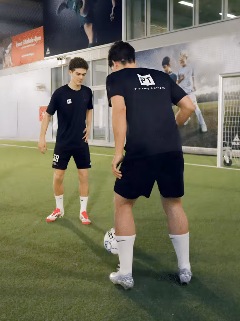 fodboldspiller laver 1 mod 1 forsvarsøvelse mod atlet under fysisk træning i fodbold