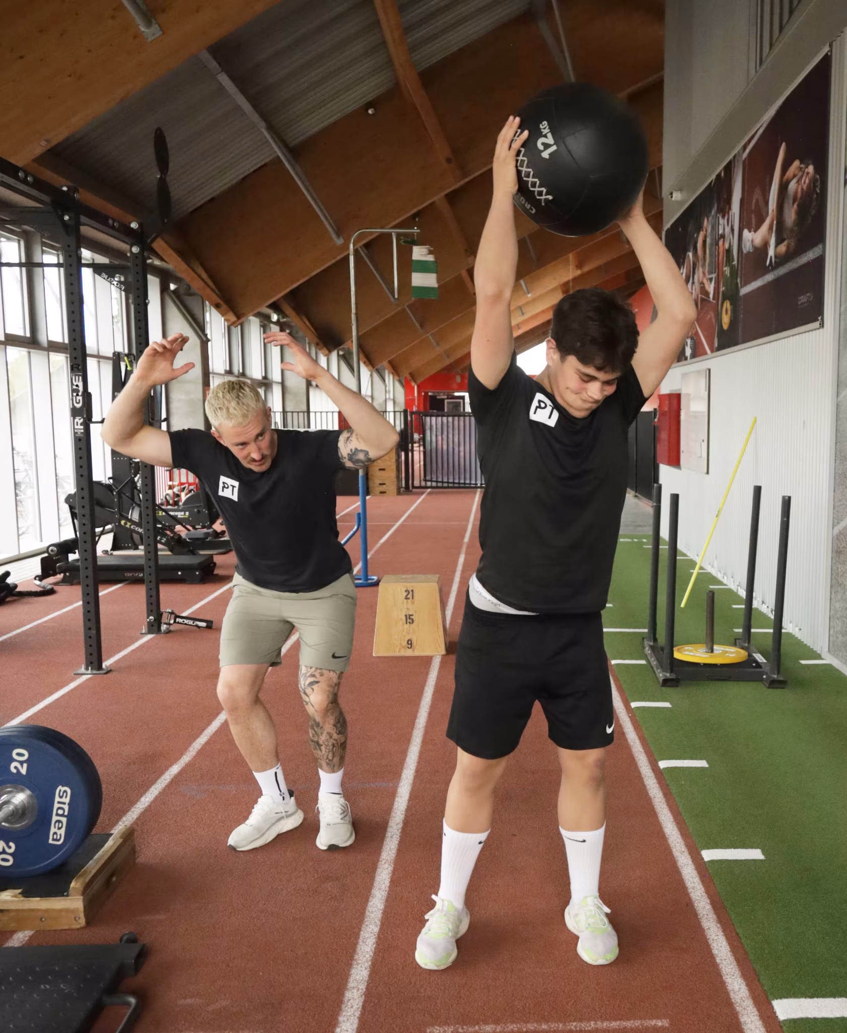 fysisk træner observerer atlet under plyometrisk træning i træningsmiljø